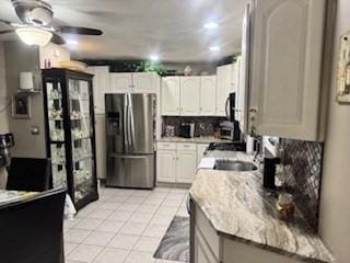 59-61 Waite St, Malden, MA 02148 - kitchen featuring stainless steel fridge, ceiling fan, light tile patterned floors, tasteful backsplash, and white cabinetry