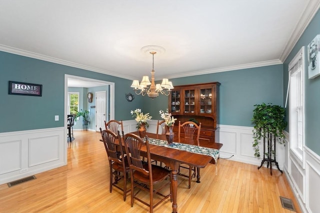 16 Preserve Way, Sturbridge, MA 01566 - dining area featuring wainscoting, a chandelier, light wood-type flooring, ornamental molding, and a decorative wall