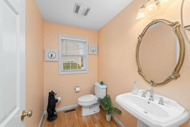 16 Preserve Way, Sturbridge, MA 01566 - half bathroom with a sink, toilet, wood finished floors, and baseboards