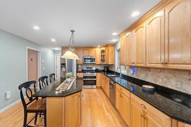 16 Preserve Way, Sturbridge, MA 01566 - kitchen featuring stainless steel appliances, a sink, a kitchen breakfast bar, light wood finished floors, and backsplash