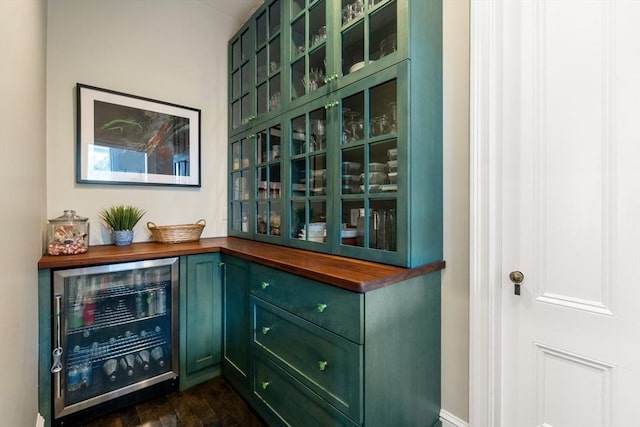 bar featuring a bar, dark wood-style floors, and beverage cooler