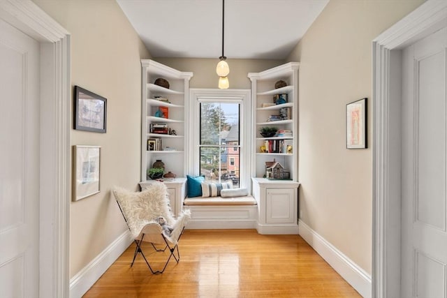 sitting room with baseboards and light wood finished floors