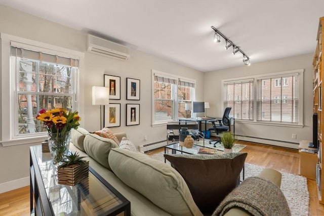 living area with a baseboard radiator, wood finished floors, an AC wall unit, and baseboards