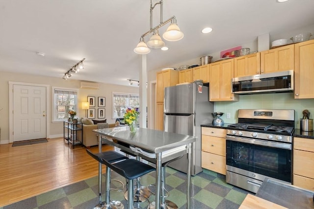 kitchen featuring a wall mounted air conditioner, stainless steel appliances, dark countertops, backsplash, and light brown cabinetry