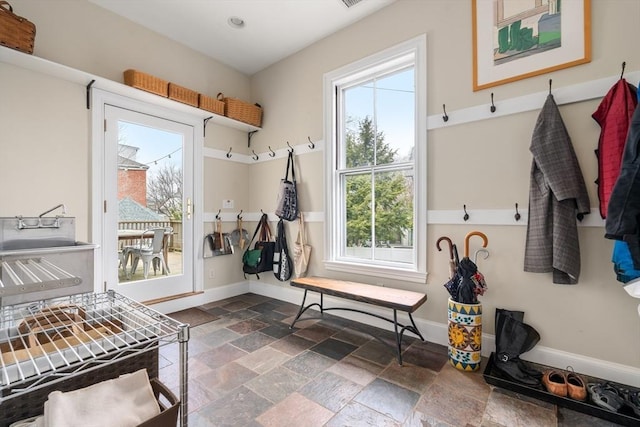 mudroom featuring stone tile flooring and baseboards