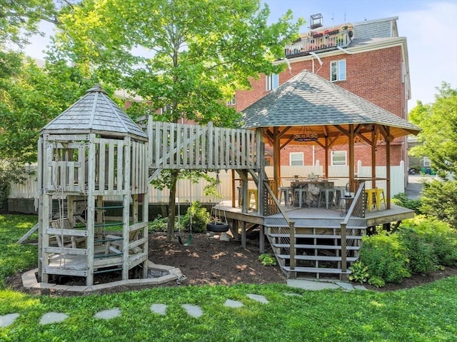 view of yard with a gazebo, a wooden deck, fence, and a playground