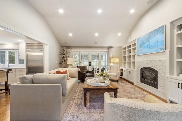 22 High St, Southborough, MA 01772 - living area with a fireplace, light wood-style floors, high vaulted ceiling, built in shelves, and recessed lighting