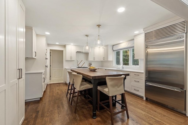 22 High St, Southborough, MA 01772 - kitchen featuring stainless steel built in fridge, wood counters, backsplash, dark wood finished floors, and white cabinetry