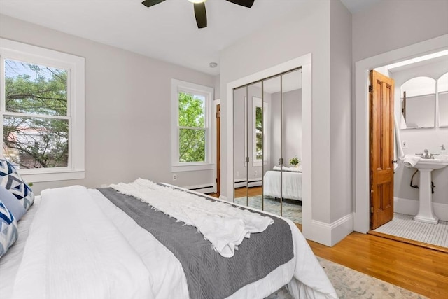 464 Windsor St Unit 3, Cambridge, MA 02141 - bedroom with wood finished floors, multiple windows, a closet, and a baseboard radiator