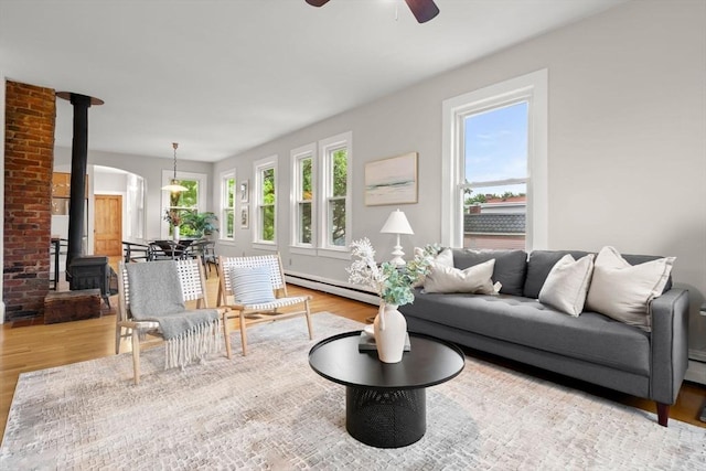464 Windsor St Unit 3, Cambridge, MA 02141 - living area with wood finished floors, plenty of natural light, a wood stove, and a ceiling fan