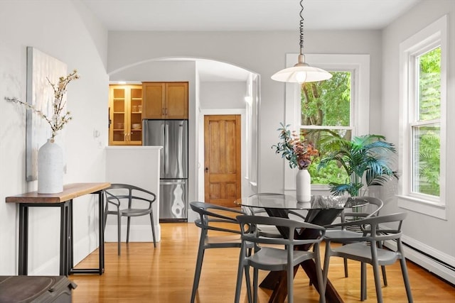 464 Windsor St Unit 3, Cambridge, MA 02141 - dining space with arched walkways, light wood-style floors, and baseboard heating