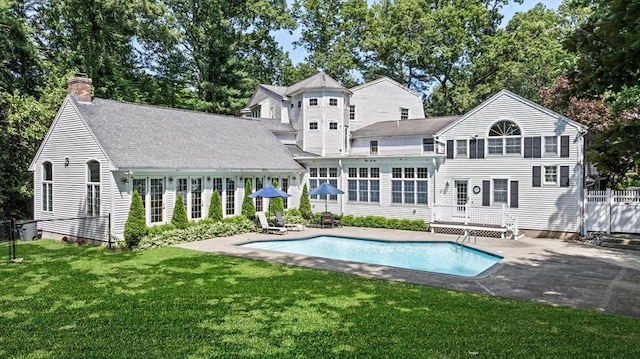 38 Lincoln Cir E, Andover, MA 01810 - back of house with a chimney, an outdoor pool, a lawn, and a patio