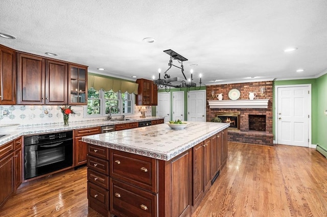 38 Lincoln Cir E, Andover, MA 01810 - kitchen with black oven, crown molding, light wood-style flooring, light countertops, and a kitchen island