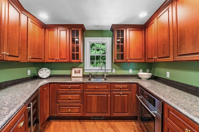 38 Lincoln Cir E, Andover, MA 01810 - kitchen with stainless steel oven, beverage cooler, glass insert cabinets, light wood-style floors, and recessed lighting
