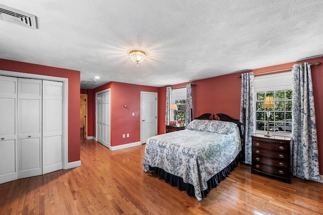 38 Lincoln Cir E, Andover, MA 01810 - bedroom featuring wood finished floors, two closets, and a textured ceiling
