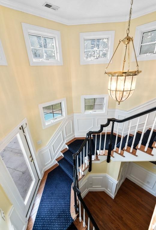 38 Lincoln Cir E, Andover, MA 01810 - stairs with wood finished floors, a chandelier, crown molding, and a decorative wall