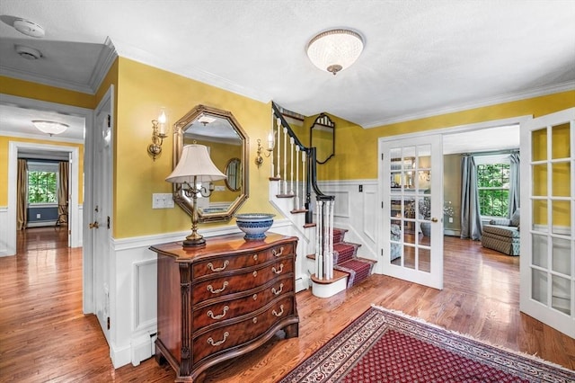 38 Lincoln Cir E, Andover, MA 01810 - entrance foyer featuring french doors, wainscoting, stairway, crown molding, and a decorative wall