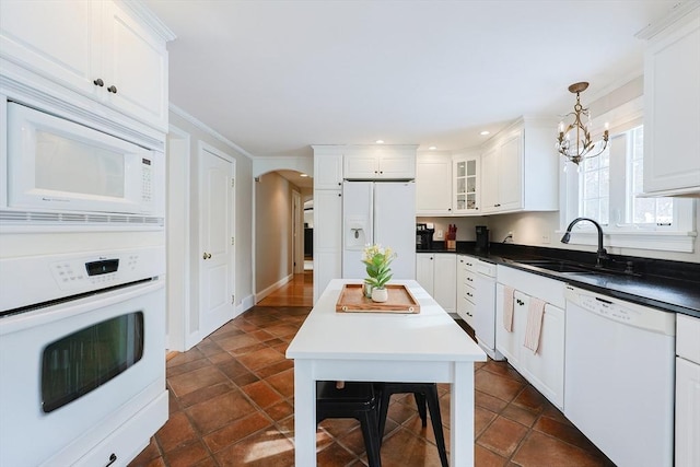 kitchen featuring pendant lighting, white cabinetry, sink, a notable chandelier, and white appliances