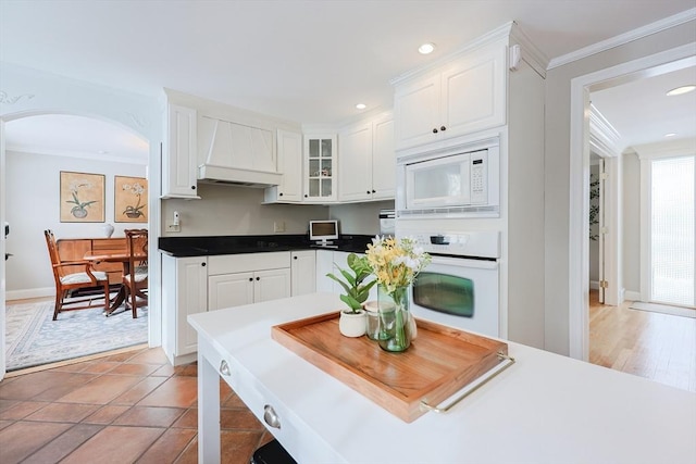 kitchen with white cabinetry, light tile patterned floors, white appliances, and ornamental molding