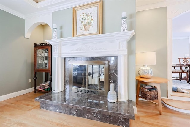 room details with ornamental molding, hardwood / wood-style floors, and a high end fireplace