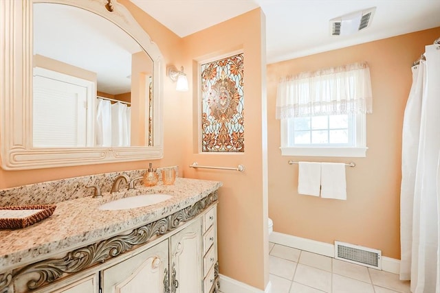 bathroom featuring tile patterned flooring, vanity, and toilet