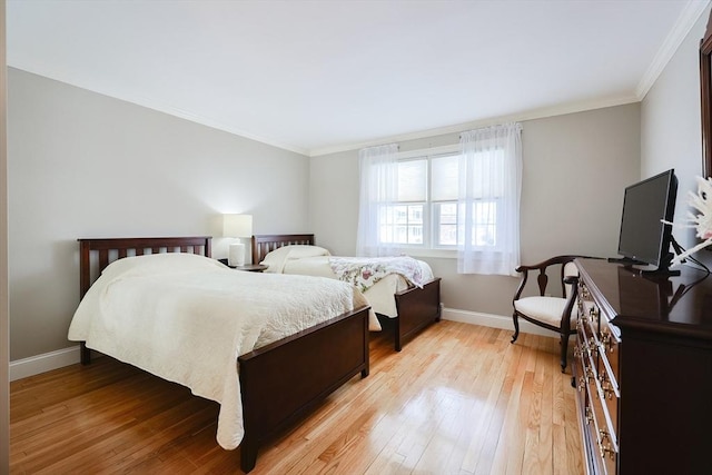 bedroom featuring ornamental molding and light hardwood / wood-style floors