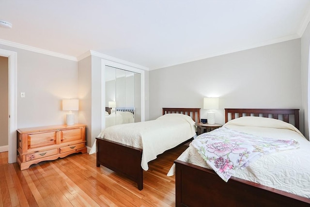 bedroom featuring hardwood / wood-style flooring, crown molding, and a closet