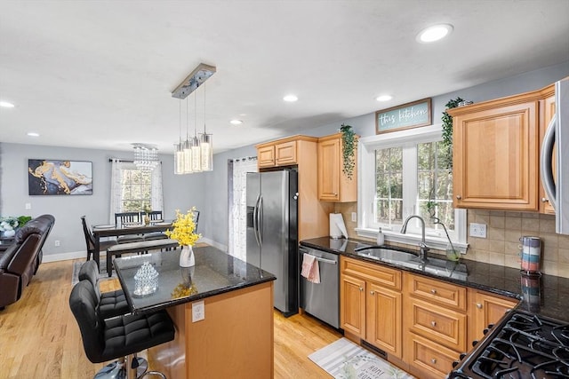 29 Regatta Dr, Attleboro, MA 02703 - kitchen with light wood-style floors, a center island, appliances with stainless steel finishes, a sink, and decorative backsplash