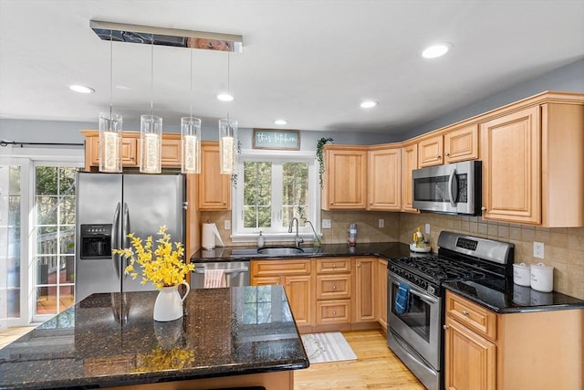 29 Regatta Dr, Attleboro, MA 02703 - kitchen featuring appliances with stainless steel finishes, light wood-type flooring, dark stone countertops, decorative backsplash, and a sink