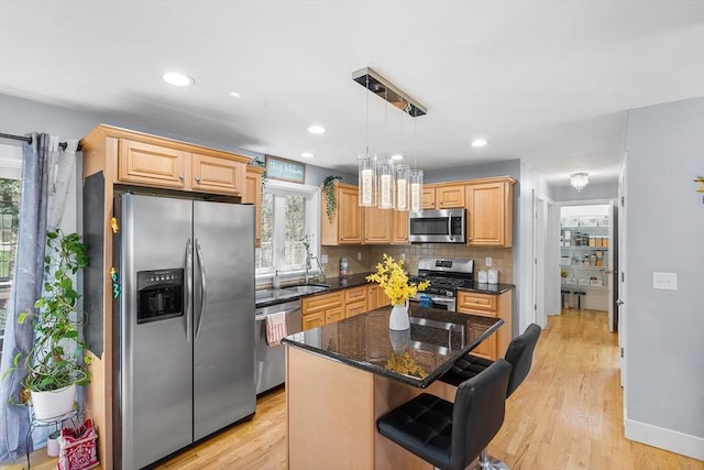 29 Regatta Dr, Attleboro, MA 02703 - kitchen featuring tasteful backsplash, a center island, a sink, appliances with stainless steel finishes, and light wood-style flooring