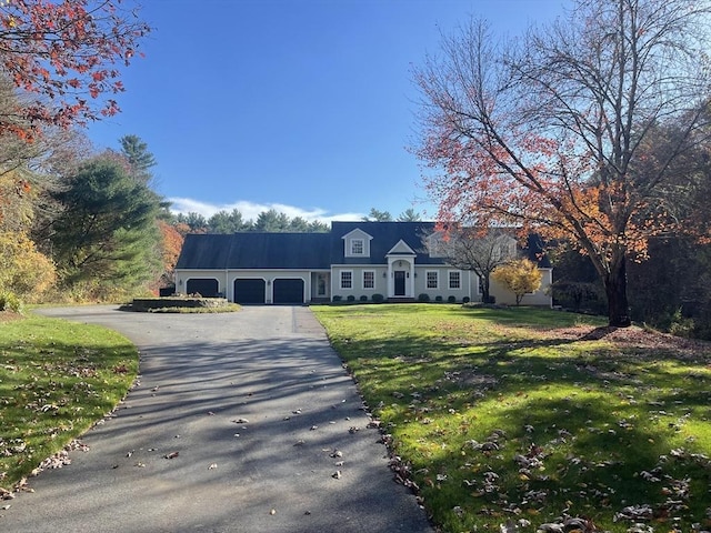 cape cod house with a garage and a front lawn