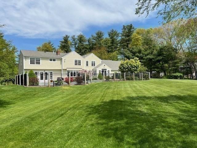 rear view of house featuring a lawn