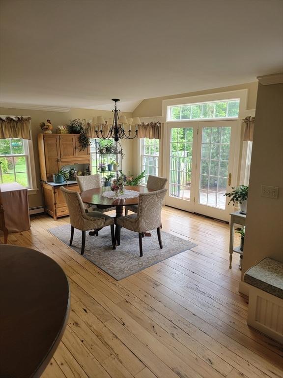 dining area with a baseboard heating unit, light hardwood / wood-style flooring, and a chandelier