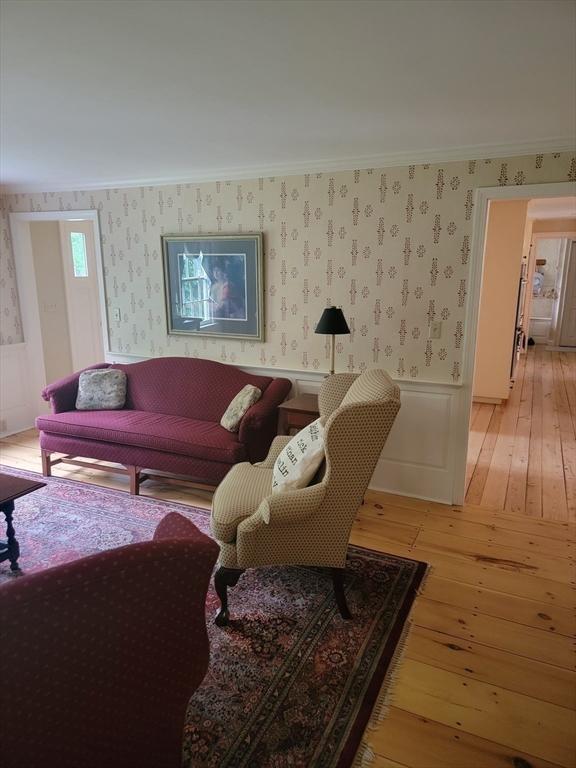 living room featuring crown molding and light wood-type flooring