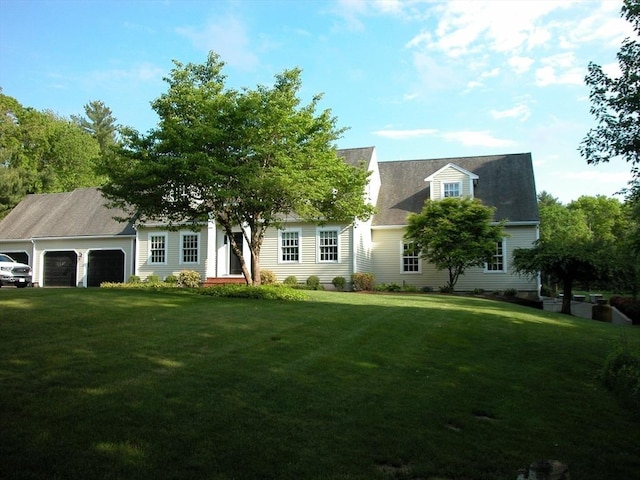 cape cod home with a front yard and a garage