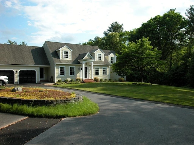 new england style home with a garage and a front lawn