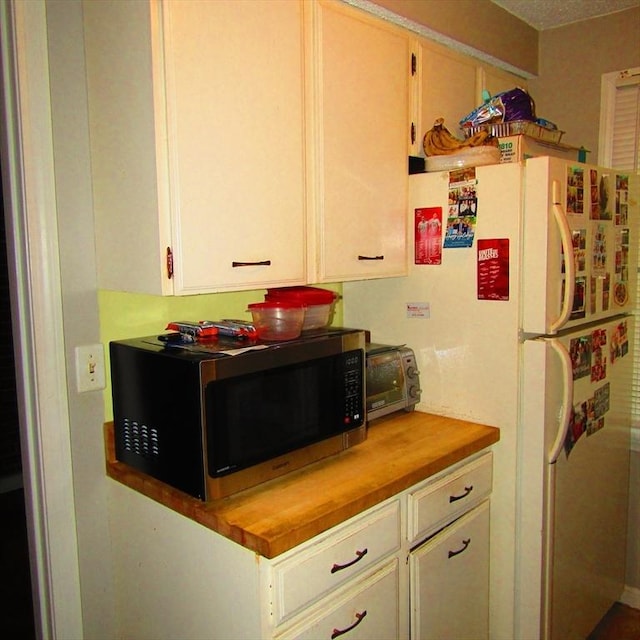 kitchen featuring wooden counters and white refrigerator