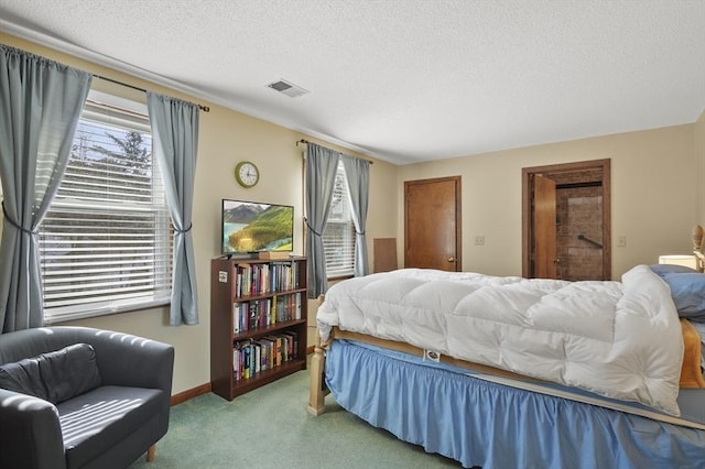 bedroom featuring carpet floors, visible vents, a textured ceiling, and baseboards