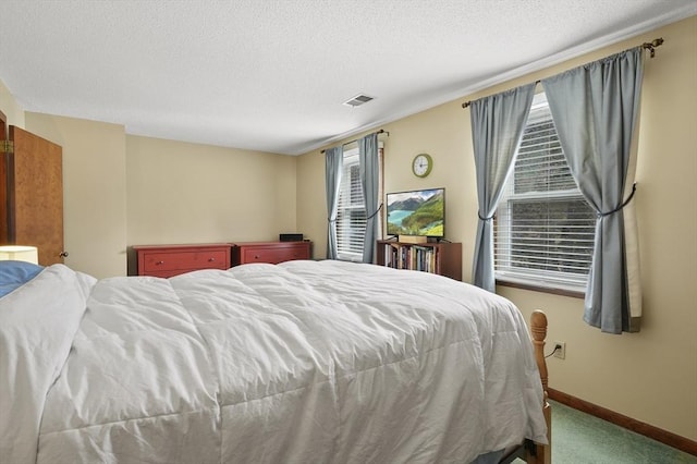 bedroom featuring carpet, visible vents, a textured ceiling, and baseboards