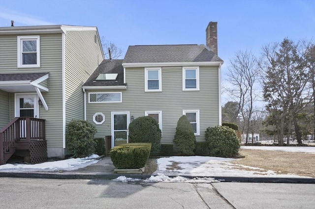 view of front of house with roof with shingles and a chimney