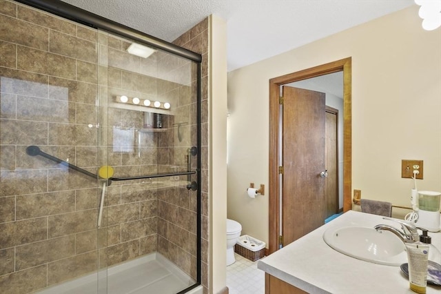 full bath featuring a textured ceiling, toilet, vanity, tile patterned floors, and a stall shower