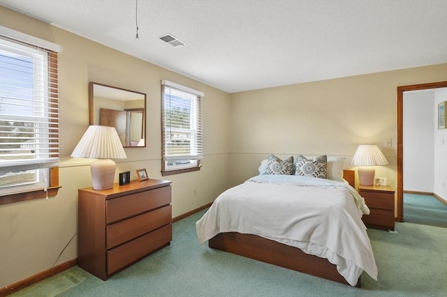 carpeted bedroom featuring baseboards, visible vents, and a textured ceiling