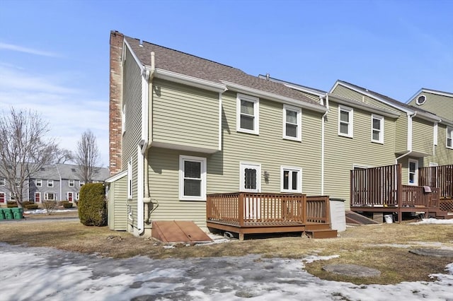 back of house featuring a chimney and a wooden deck