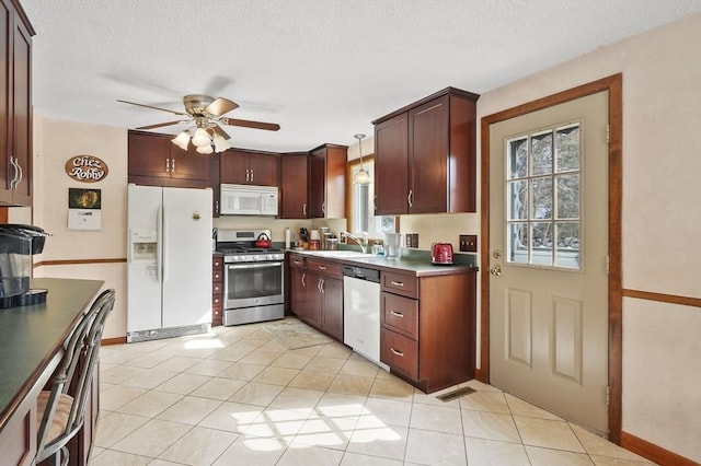 kitchen with a textured ceiling, white appliances, a sink, and a ceiling fan