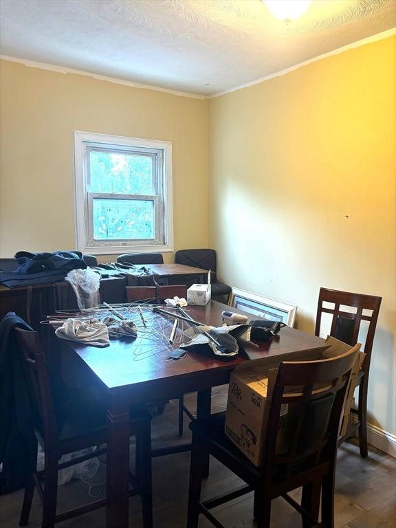 dining area with hardwood / wood-style floors and crown molding