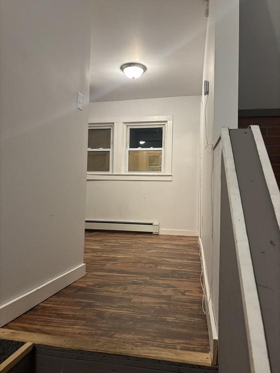 hall featuring a baseboard heating unit and dark hardwood / wood-style flooring