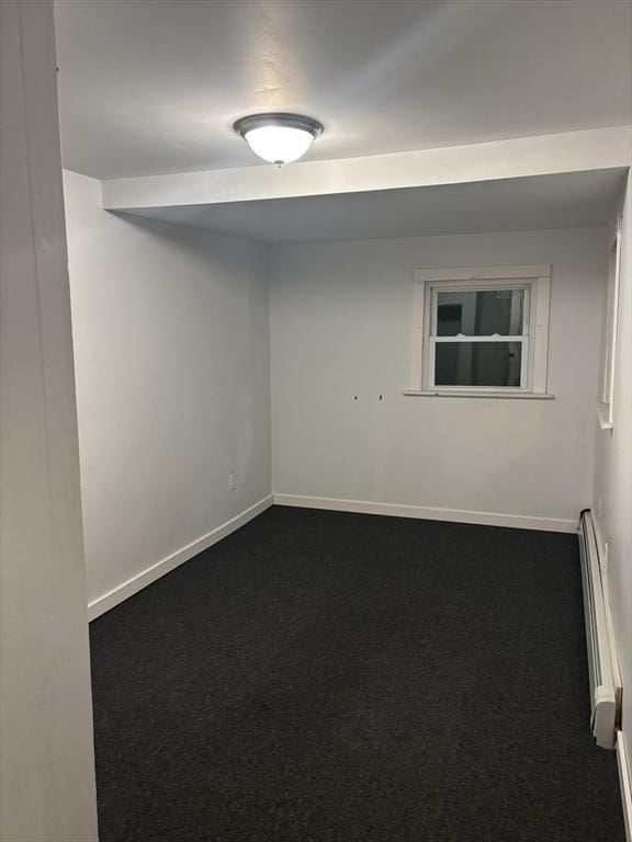 empty room featuring carpet floors and a baseboard radiator