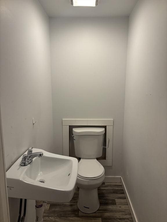 bathroom with toilet, hardwood / wood-style floors, and sink