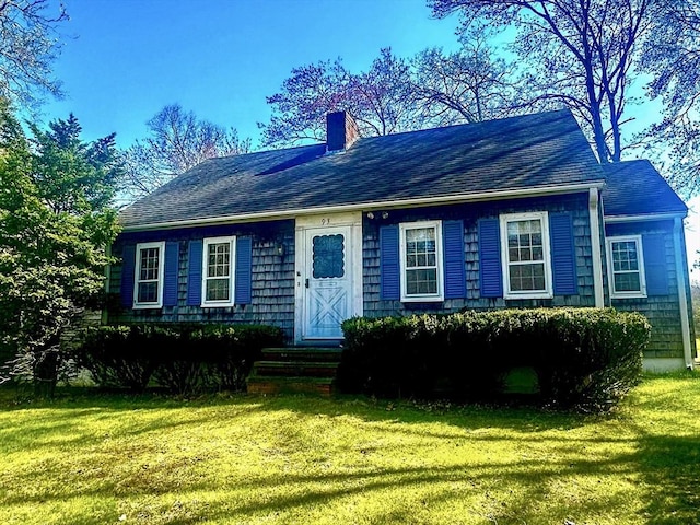 view of front of home with a chimney, a front lawn, and roof with shingles