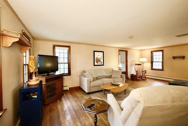 living room with hardwood / wood-style flooring, crown molding, a baseboard heating unit, and baseboards